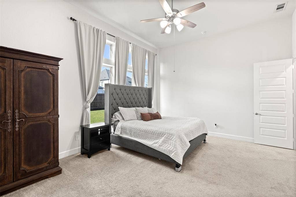 2837 Midlake Drive, Midlothian, TX 76065 Spacious bedroom featuring light-colored carpeting, white baseboards, and a ceiling fan with integrated lighting