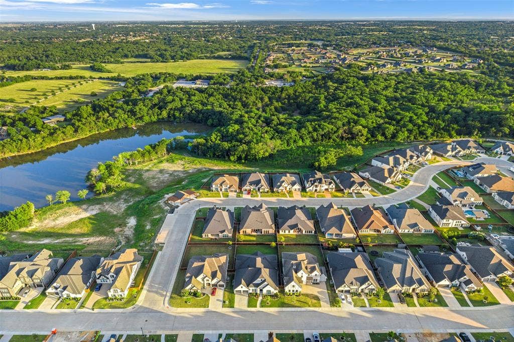 2837 Midlake Drive, Midlothian, TX 76065 Aerial perspective showcasing a residential development with a curving street layout, surrounded by extensive green spaces and a prominent body of water