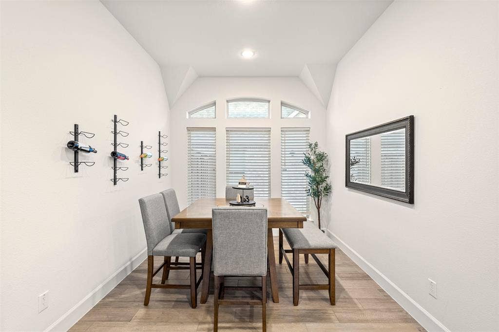 2837 Midlake Drive, Midlothian, TX 76065 Dining area featuring wood-finish flooring, white baseboards, and a vaulted ceiling