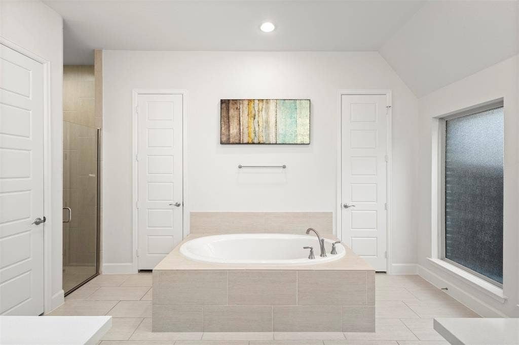 2837 Midlake Drive, Midlothian, TX 76065 Spacious bathroom featuring a built-in soaking tub, a separate glass-enclosed shower, tile flooring, and a frosted privacy window