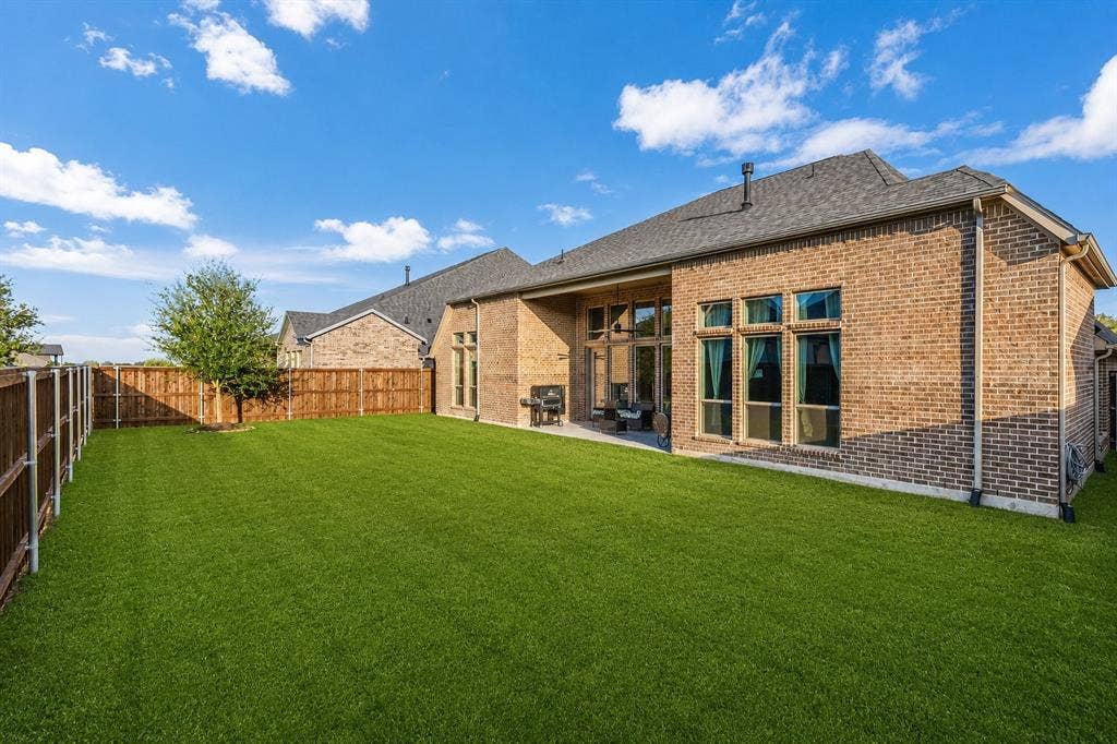 2837 Midlake Drive, Midlothian, TX 76065 Expansive backyard featuring a lush lawn, privacy fencing, and a covered patio area