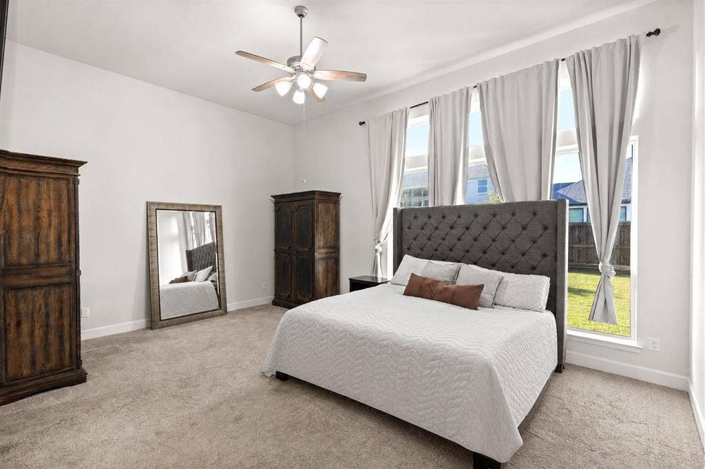 2837 Midlake Drive, Midlothian, TX 76065 Spacious bedroom featuring multiple tall windows, vaulted ceilings, and plush carpet flooring