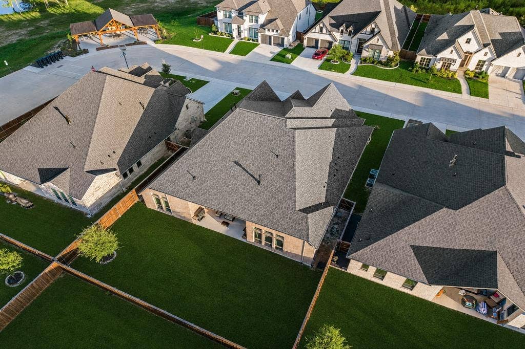 2837 Midlake Drive, Midlothian, TX 76065 Aerial perspective showcasing a residential property featuring a multi-pitched shingle roof and a spacious, fenced backyard with manicured lawn