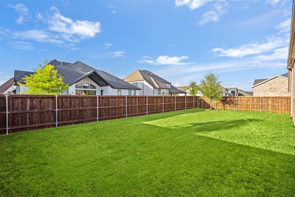 2837 Midlake Drive, Midlothian, TX 76065 Expansive green lawn with a full wood privacy fence and mature trees
