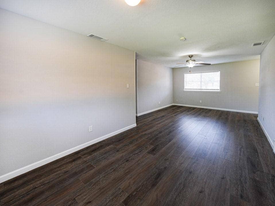 1205 Northridge Drive, Plano, TX 75075 Wood-finish flooring, neutral wall tones, ceiling fan with integrated lighting, and multiple windows