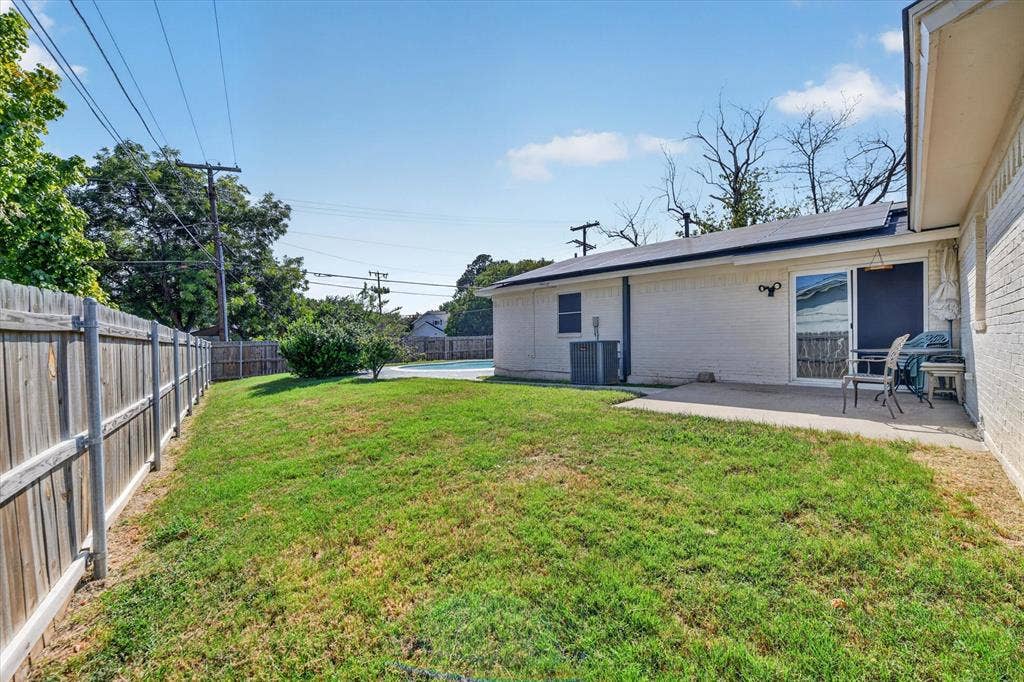 629 Newton Drive, Burleson, TX 76028 Expansive grassy yard with wood fencing and a concrete patio
