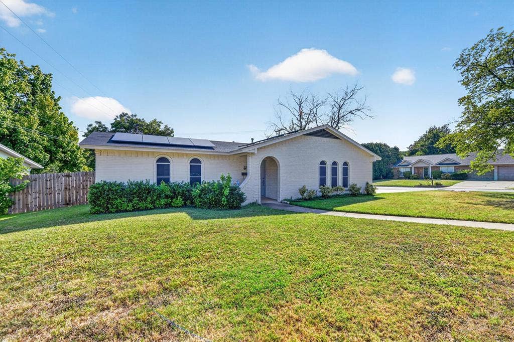 629 Newton Drive, Burleson, TX 76028 Charming single-story residence featuring a stucco exterior with arched entryway and rounded architectural details