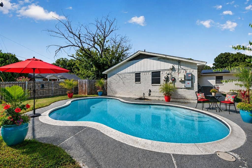 629 Newton Drive, Burleson, TX 76028 Virtually staged Freeform swimming pool with a light grey coping and dark grey deck surround