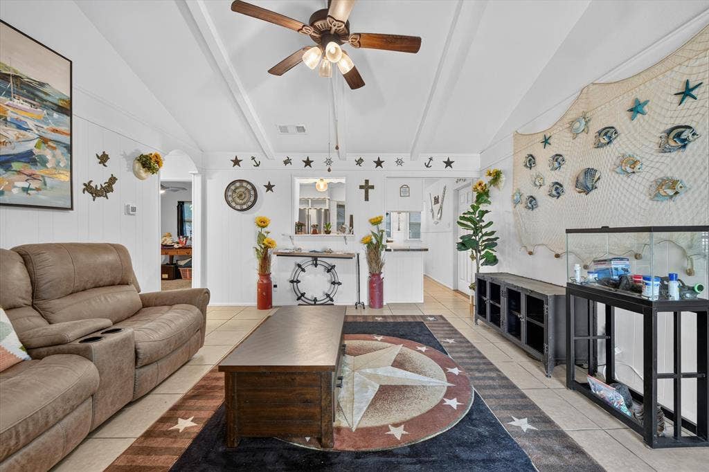 629 Newton Drive, Burleson, TX 76028 Bright and spacious living area showcasing crisp white ceilings with ceiling fan, wood-finish flooring, and geometric area rug
