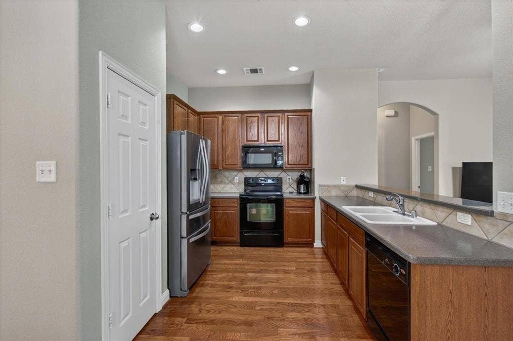 10165 Bantry Lane, Forney, TX 75126 Open kitchen with corian countertops and a breakfast bar open to the living room