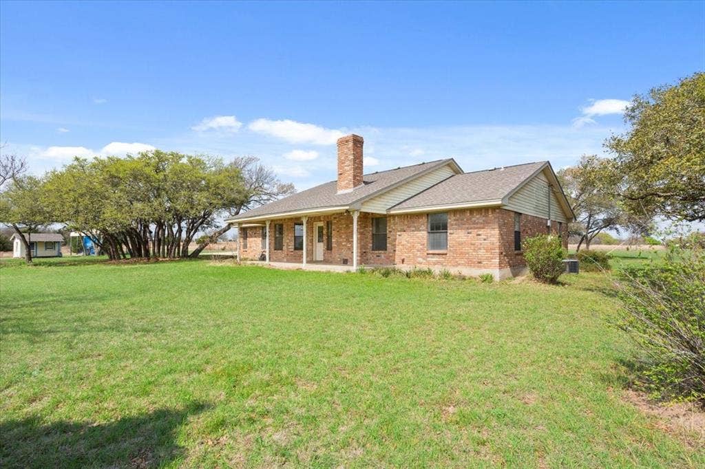 146 Indian Paint Brush Road, Eddy, TX 76524 Brick exterior with a prominent chimney, a covered porch, and a gabled roofline