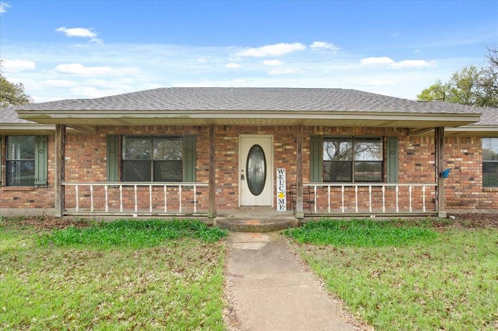 146 Indian Paint Brush Road, Eddy, TX 76524 Brick exterior featuring a covered front porch with wood columns and a white railing