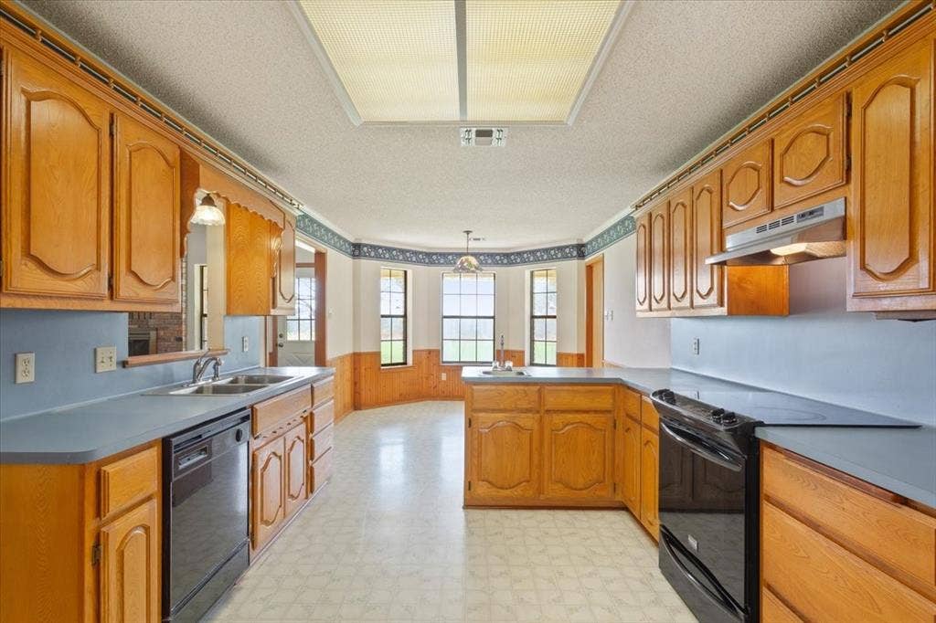 146 Indian Paint Brush Road, Eddy, TX 76524 Kitchen featuring wood cabinetry, light countertops, and an integrated double basin sink