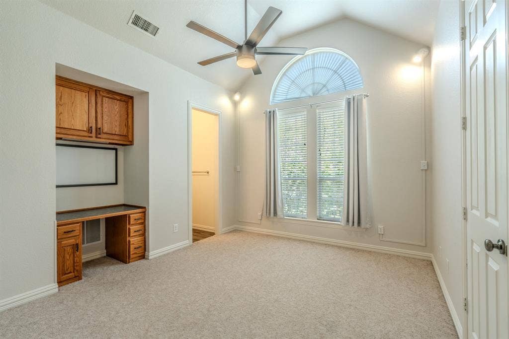 6420 Shady Oaks Lane, Midlothian, TX 76065 Bedroom 2 with built-in desk, cabinetry, large windows with natural light, fun, decorative lighting, walk-in closet, and an ensuite bathroom.