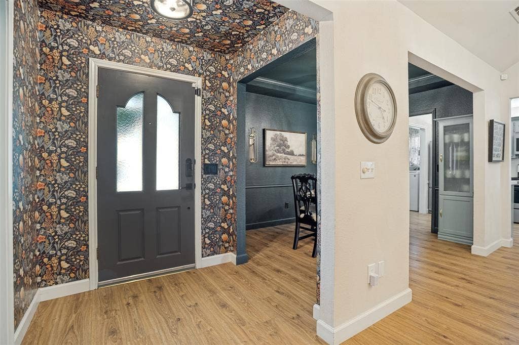 8201 Christie Drive, Frisco, TX 75033 Entryway with patterned wallpaper, wood-finish flooring, and a contemporary ceiling light fixture