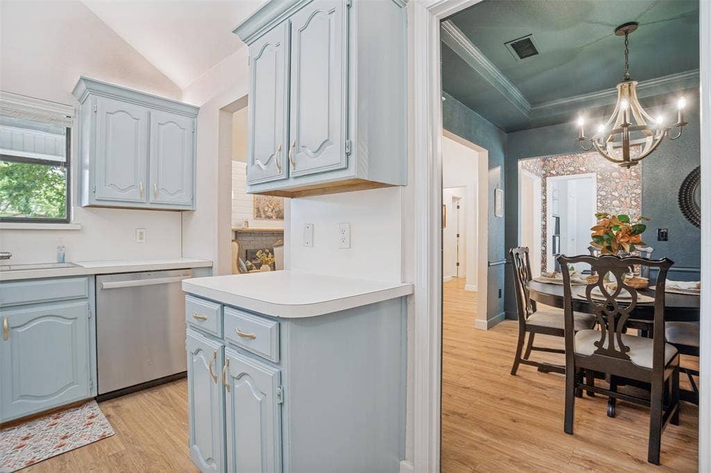8201 Christie Drive, Frisco, TX 75033 Kitchen featuring light blue cabinetry, white countertops, a stainless steel dishwasher, and wood-finish flooring