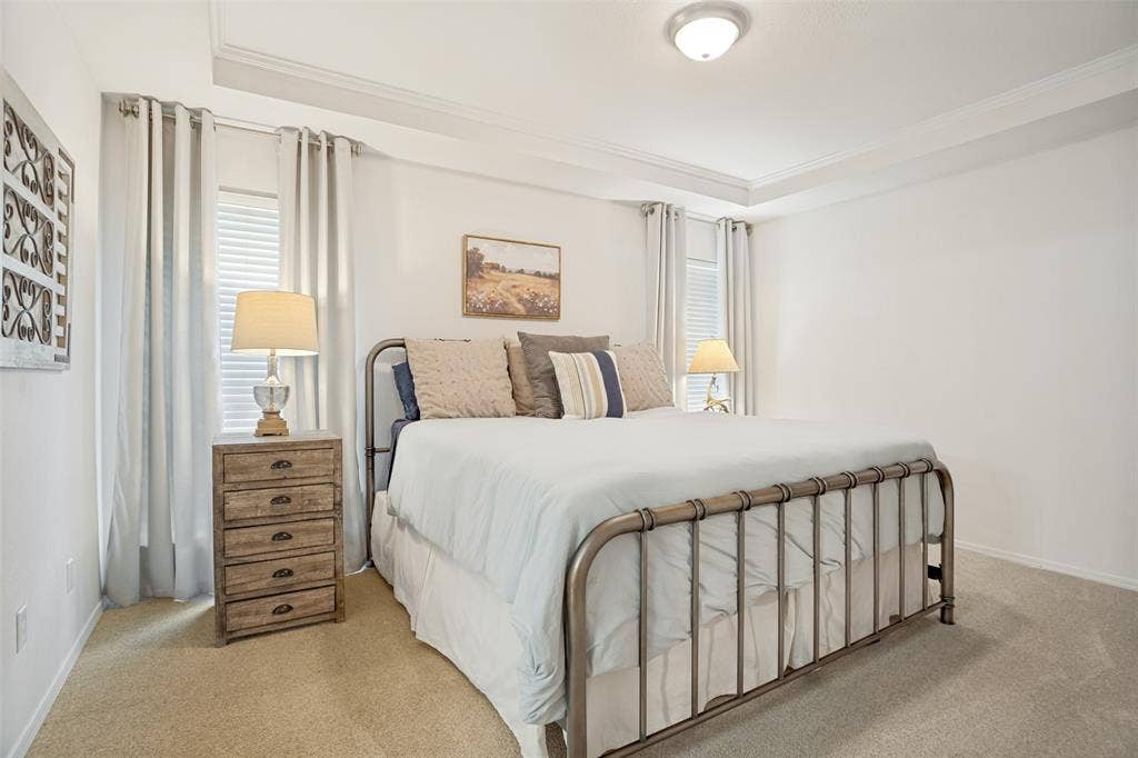 8201 Christie Drive, Frisco, TX 75033 Bedroom featuring a tray ceiling with crown molding, carpet flooring, and two windows with blinds