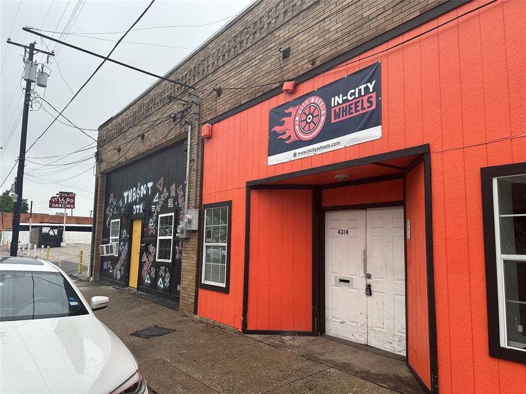4314 Elm Street, Dallas, TX 75226 Commercial building featuring an orange facade with dark trim, a recessed entrance, and a secondary black facade with multiple windows
