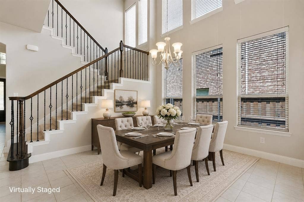 4109 Rainey Street, McKinney, TX 75070 Two-story ceilings with high windows, a chandelier light fixture, iron baluster staircase, and tile flooring