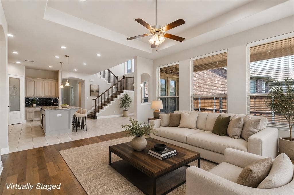 4109 Rainey Street, McKinney, TX 75070 Open-concept living area featuring a cream upholstered sofa, wood-finish flooring, and a dark wood coffee table