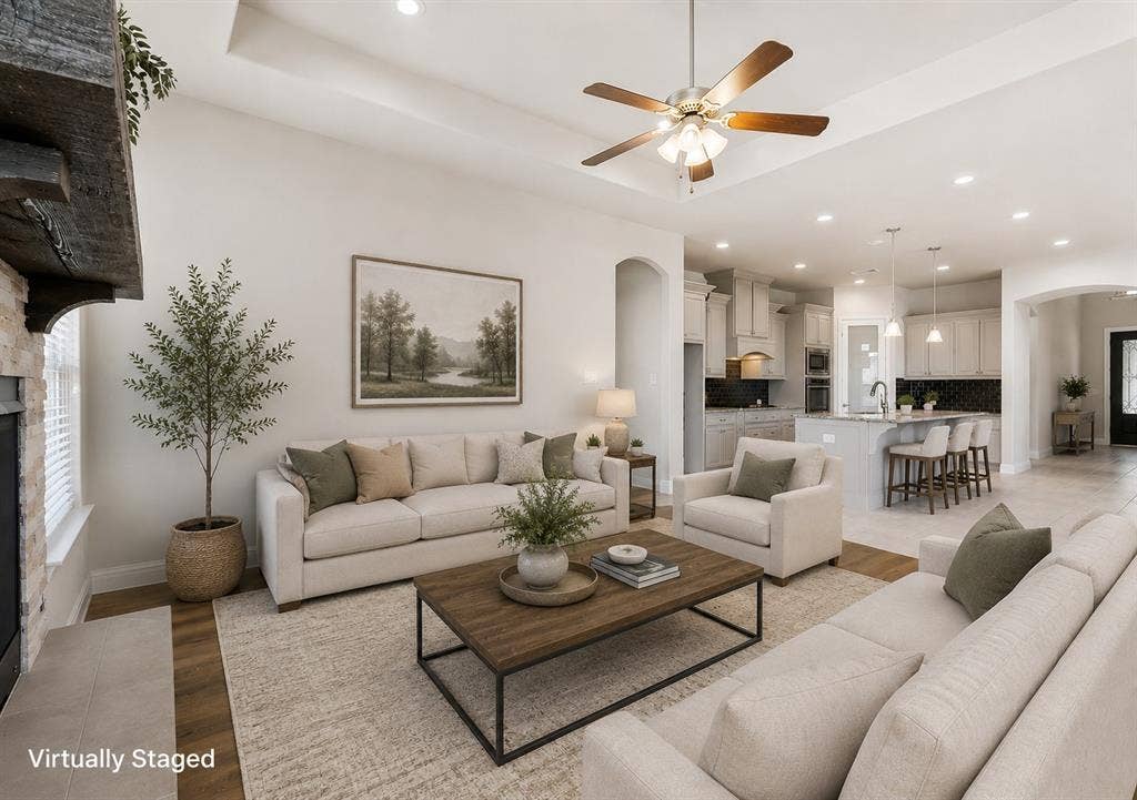 4109 Rainey Street, McKinney, TX 75070 Open-concept living area featuring a tray ceiling, recessed lighting, and wood-finish flooring