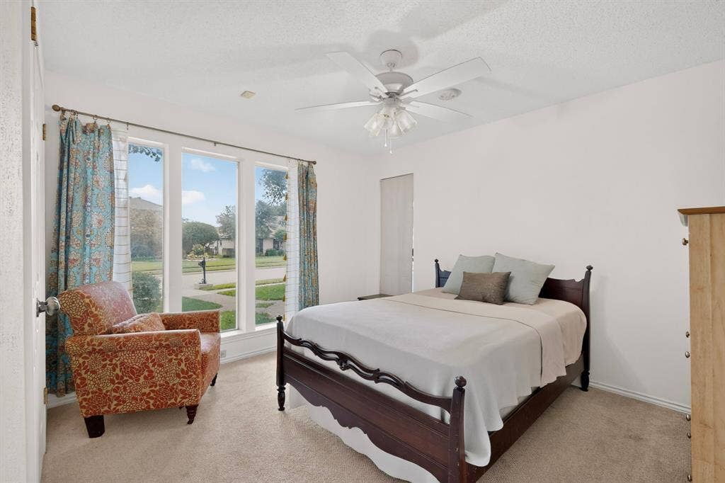 2003 J J Pearce Drive, Richardson, TX 75081 Carpeted room featuring a ceiling fan with light fixture and a three-panel window overlooking the street