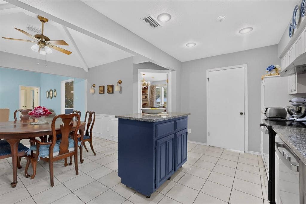 2003 J J Pearce Drive, Richardson, TX 75081 Kitchen featuring a blue island with a granite countertop, tile flooring, recessed lighting, and stainless steel appliances
