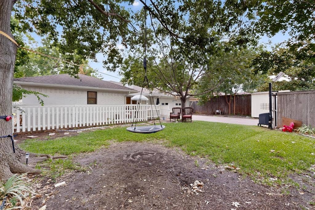 2003 J J Pearce Drive, Richardson, TX 75081 White picket fence enclosing a paved patio and Dog run area and tree swing