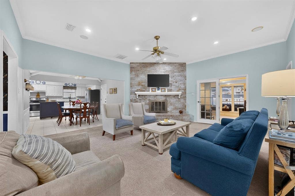 2003 J J Pearce Drive, Richardson, TX 75081 Spacious living area featuring a brick-clad fireplace with a white mantel, recessed lighting, and crown molding