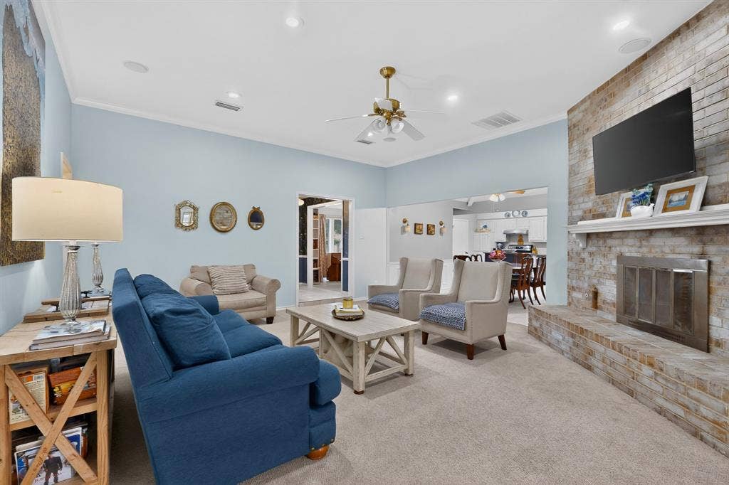 2003 J J Pearce Drive, Richardson, TX 75081 Living area featuring a textured brick fireplace with a mantel, vaulted ceilings, and recessed lighting