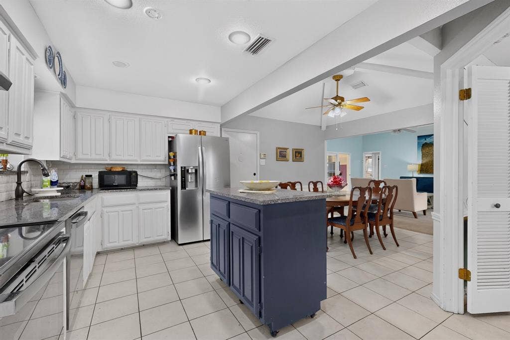 2003 J J Pearce Drive, Richardson, TX 75081 Kitchen featuring white cabinetry, dark granite countertops, and tile flooring
