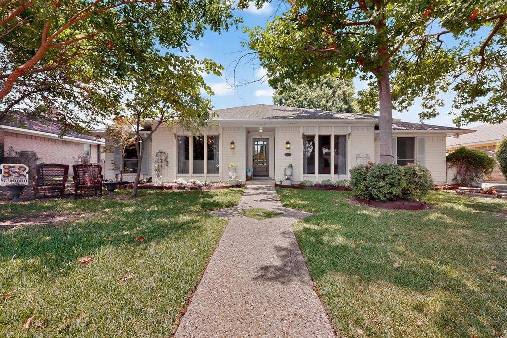 2003 J J Pearce Drive, Richardson, TX 75081 White exterior residence featuring a gabled roofline and multiple large windows