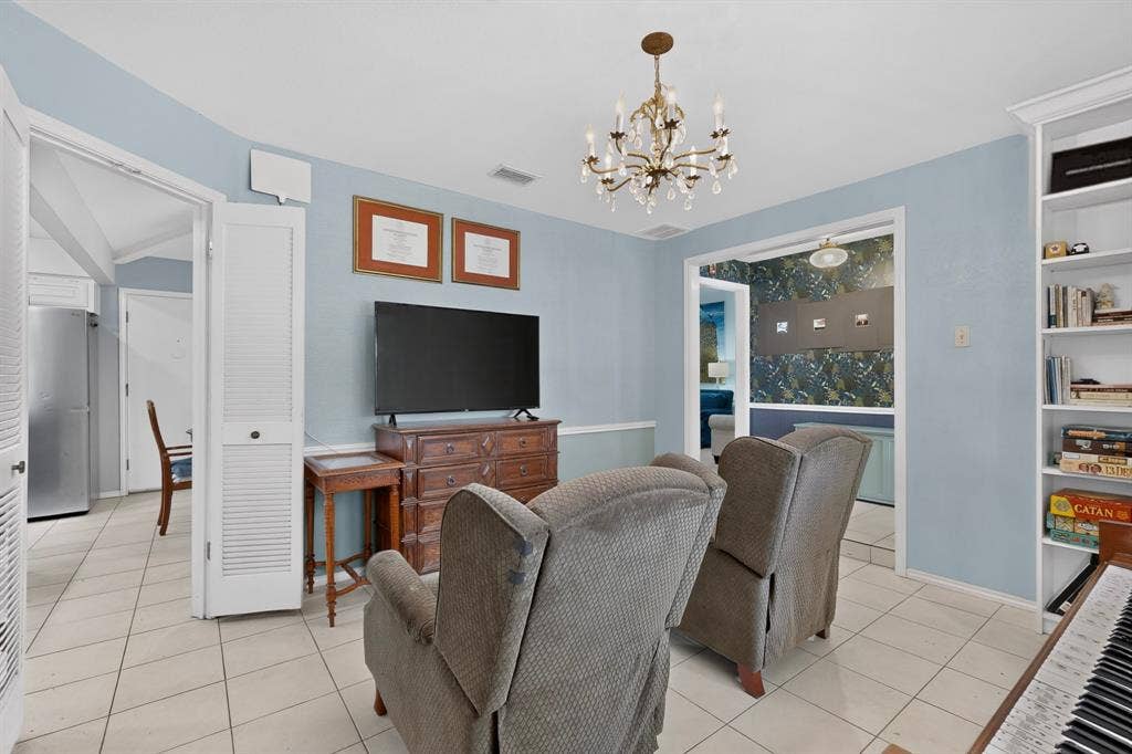2003 J J Pearce Drive, Richardson, TX 75081 Living area featuring tile flooring, a decorative chandelier, and a built-in shelving unit