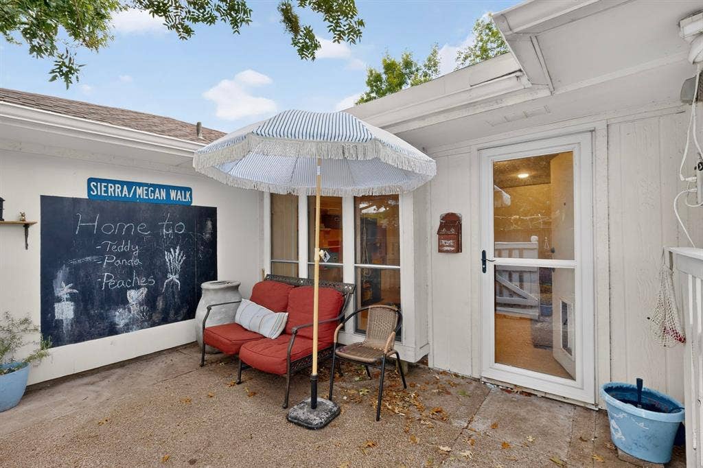 2003 J J Pearce Drive, Richardson, TX 75081 Private patio area featuring a concrete surface, a built-in chalkboard wall, and a glass-paneled exterior door