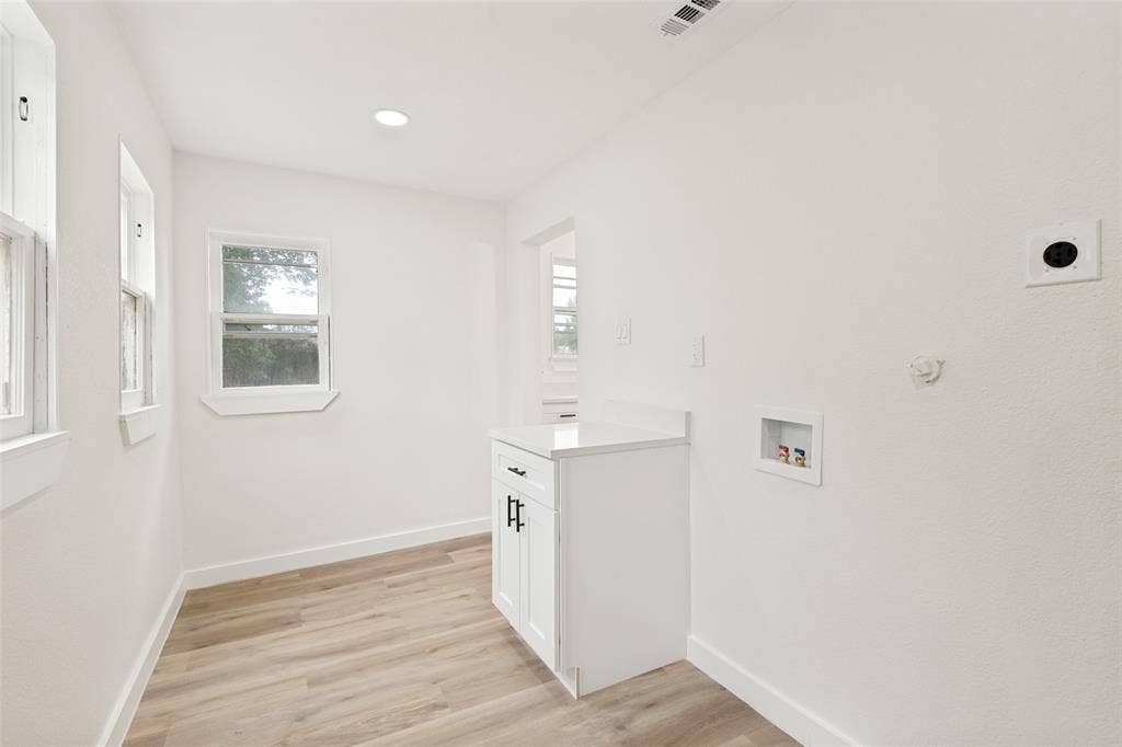 Utility space featuring light wood-finish flooring, white walls, and recessed lighting