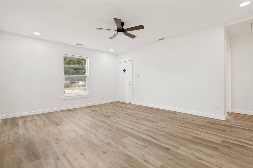 Spacious room featuring wood-finish flooring, recessed lighting, and a contemporary ceiling fan
