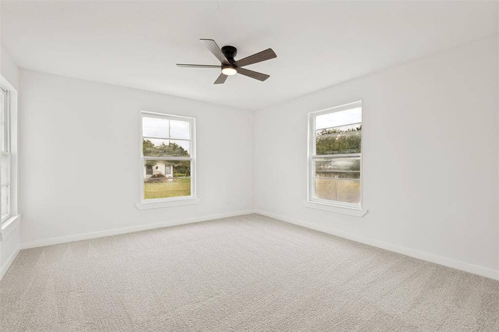 Spacious room featuring light-toned carpet flooring and white painted walls