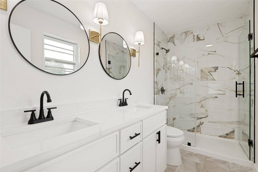 Dual vanity featuring undermount sinks, matte black faucets, and white countertops