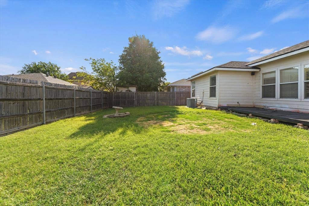 2312 Corral Drive, Fort Worth, TX 76133 Expansive grassy yard with wood fencing and a concrete patio