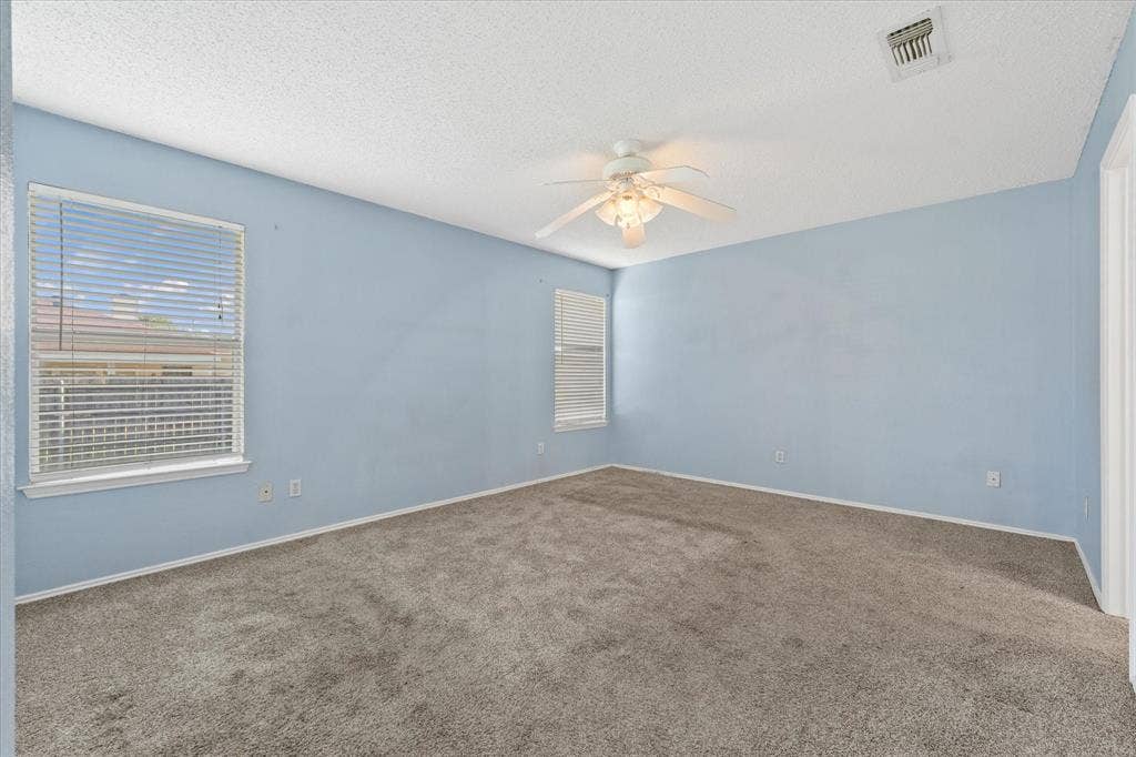 2312 Corral Drive, Fort Worth, TX 76133 Spacious room featuring carpeting, multiple windows, and a ceiling fan