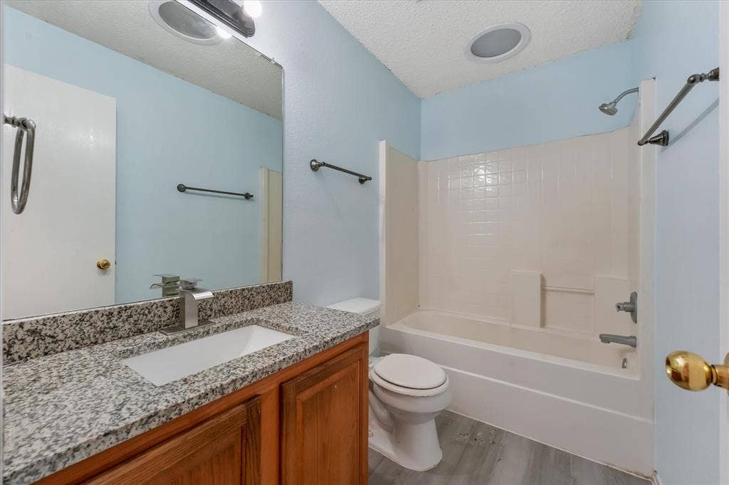 2312 Corral Drive, Fort Worth, TX 76133 Bathroom featuring a vanity with a light-toned countertop, integrated sink, and brushed nickel faucet