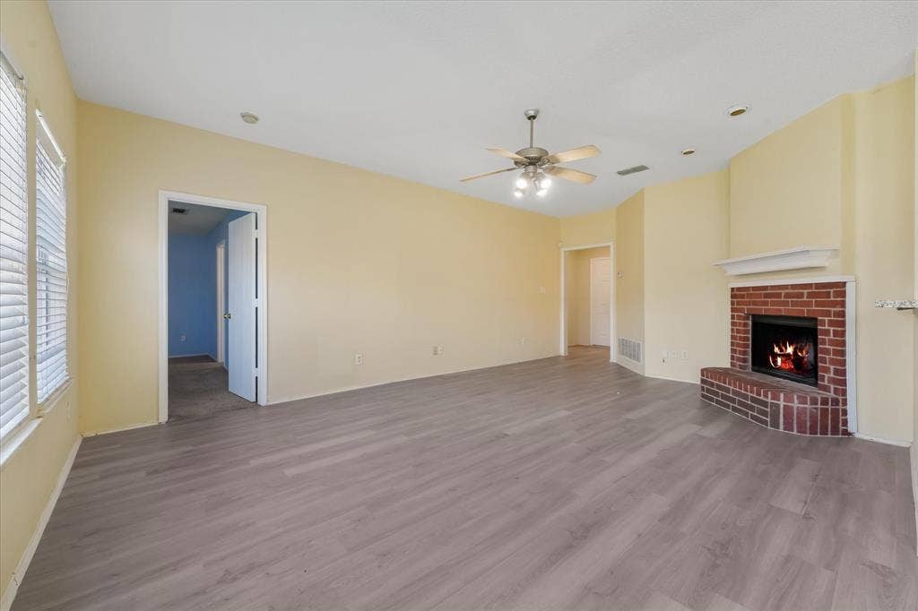 2312 Corral Drive, Fort Worth, TX 76133 Wood-finish flooring, brick fireplace with mantel, vaulted ceiling, ceiling fan, and recessed lighting