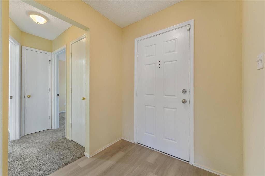 2312 Corral Drive, Fort Worth, TX 76133 Entryway featuring wood-finish flooring, a six-panel door, and neutral wall tones
