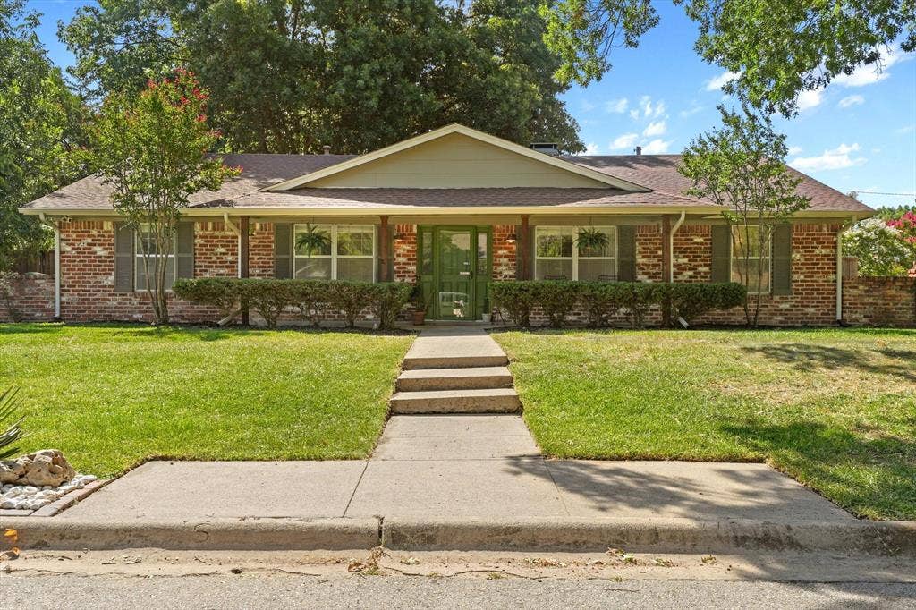 1112 Woodmount Court, Denton, TX 76209 Classic brick exterior with mature landscaping, covered front porch, oversized front yard, and established shade trees in one of Denton's most desirable neighborhoods near Nette Shultz Elementary.