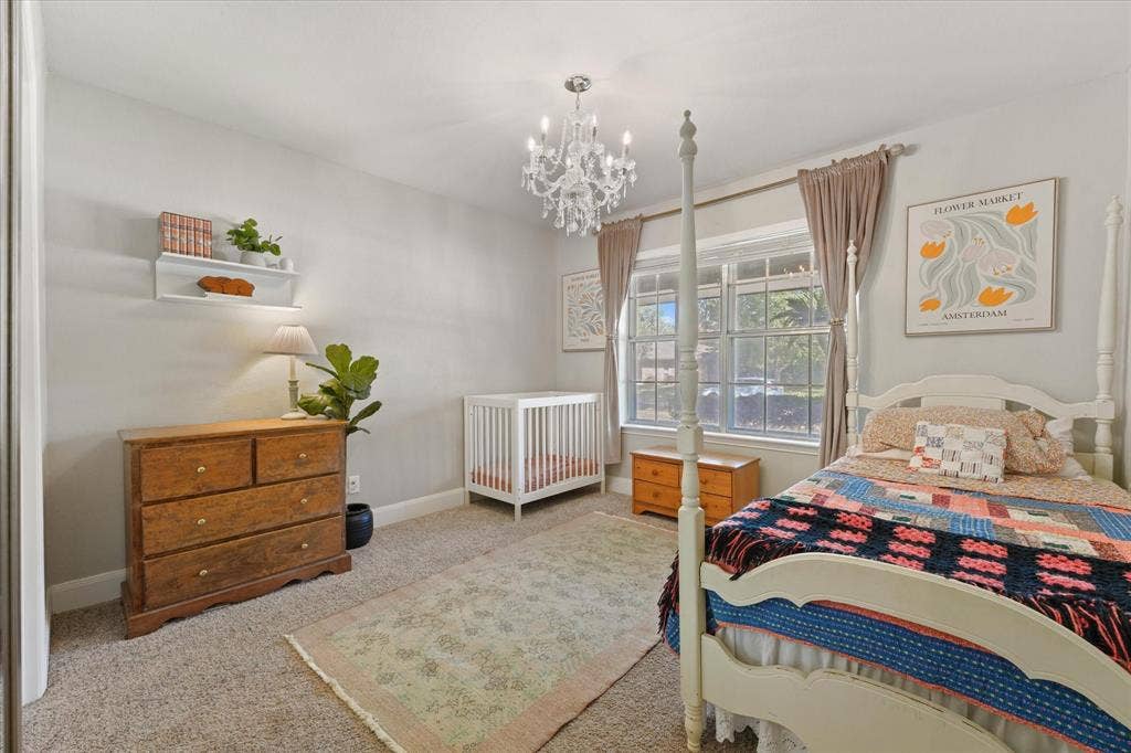 1112 Woodmount Court, Denton, TX 76209 Generously sized secondary bedroom with updated lighting, large windows for natural light, and ample space for a nursery or guest bedroom.
