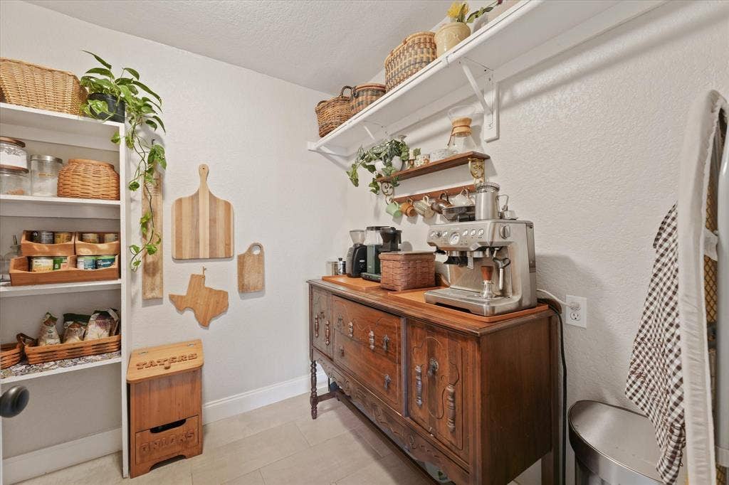 1112 Woodmount Court, Denton, TX 76209 Large walk-in pantry with built-in shelving, extensive storage space, and room for small appliances and kitchen organization.