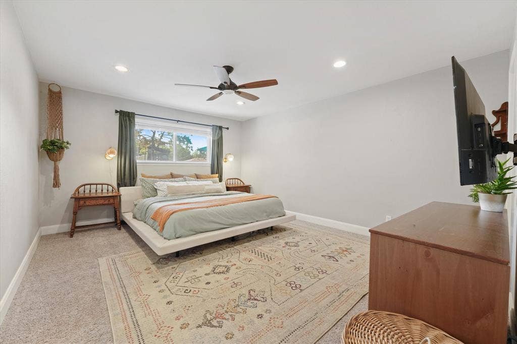 1112 Woodmount Court, Denton, TX 76209 Spacious primary suite with recessed lighting, updated ceiling fan, large picture window, and plenty of room for a king-size bed and additional furniture.