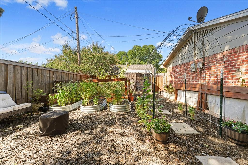 1112 Woodmount Court, Denton, TX 76209 Dedicated garden area with raised beds, trellises, and space for growing vegetables, herbs, and flowers—perfect for gardening enthusiasts.
