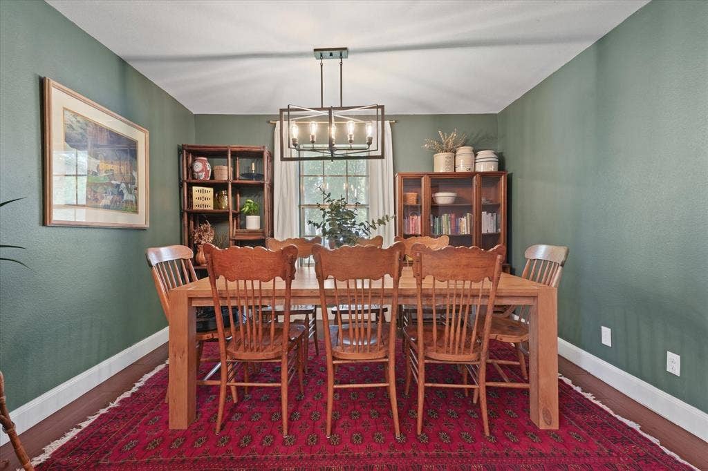 1112 Woodmount Court, Denton, TX 76209 Dedicated dining room with designer lighting, rich accent walls, hardwood floors, and plenty of space for hosting family gatherings and holidays.