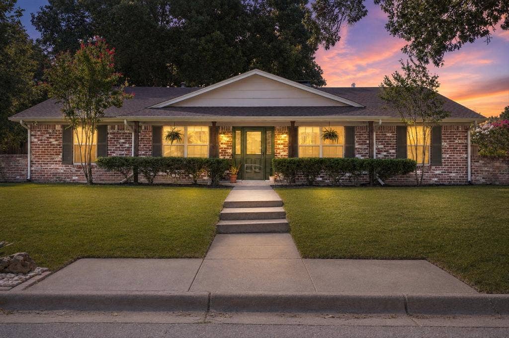 1112 Woodmount Court, Denton, TX 76209 Twilight view of this beautifully renovated brick home on a quiet cul-de-sac in Denton's sought-after Idiot's Hill neighborhood with mature trees, covered front porch, and welcoming curb appeal.